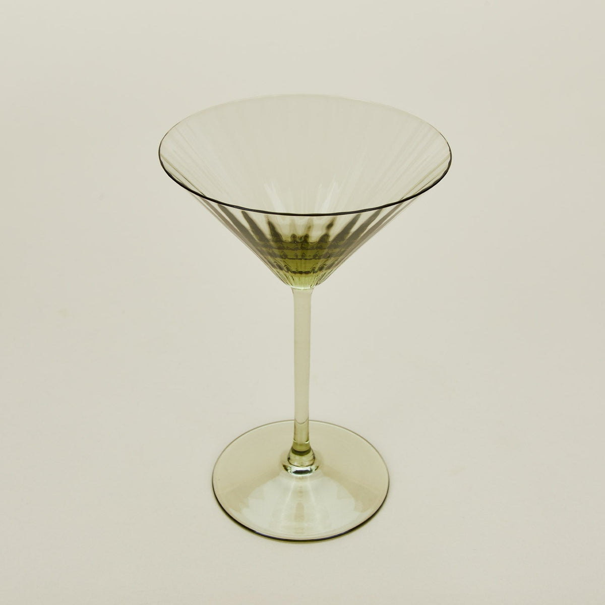 Three-quarter angle of ribbed olive martini glass.