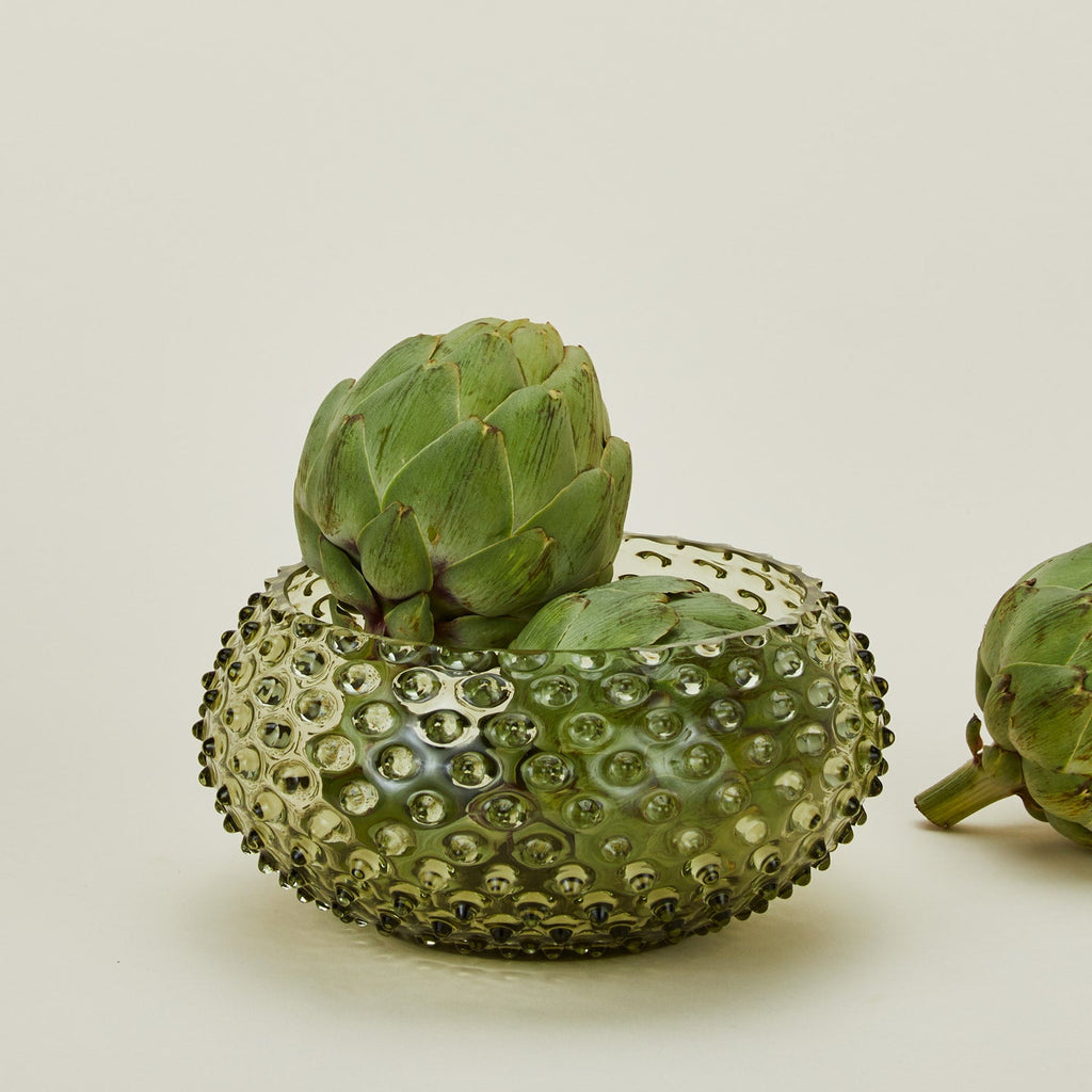 Glass hobnail olive serving bowl with artichokes.