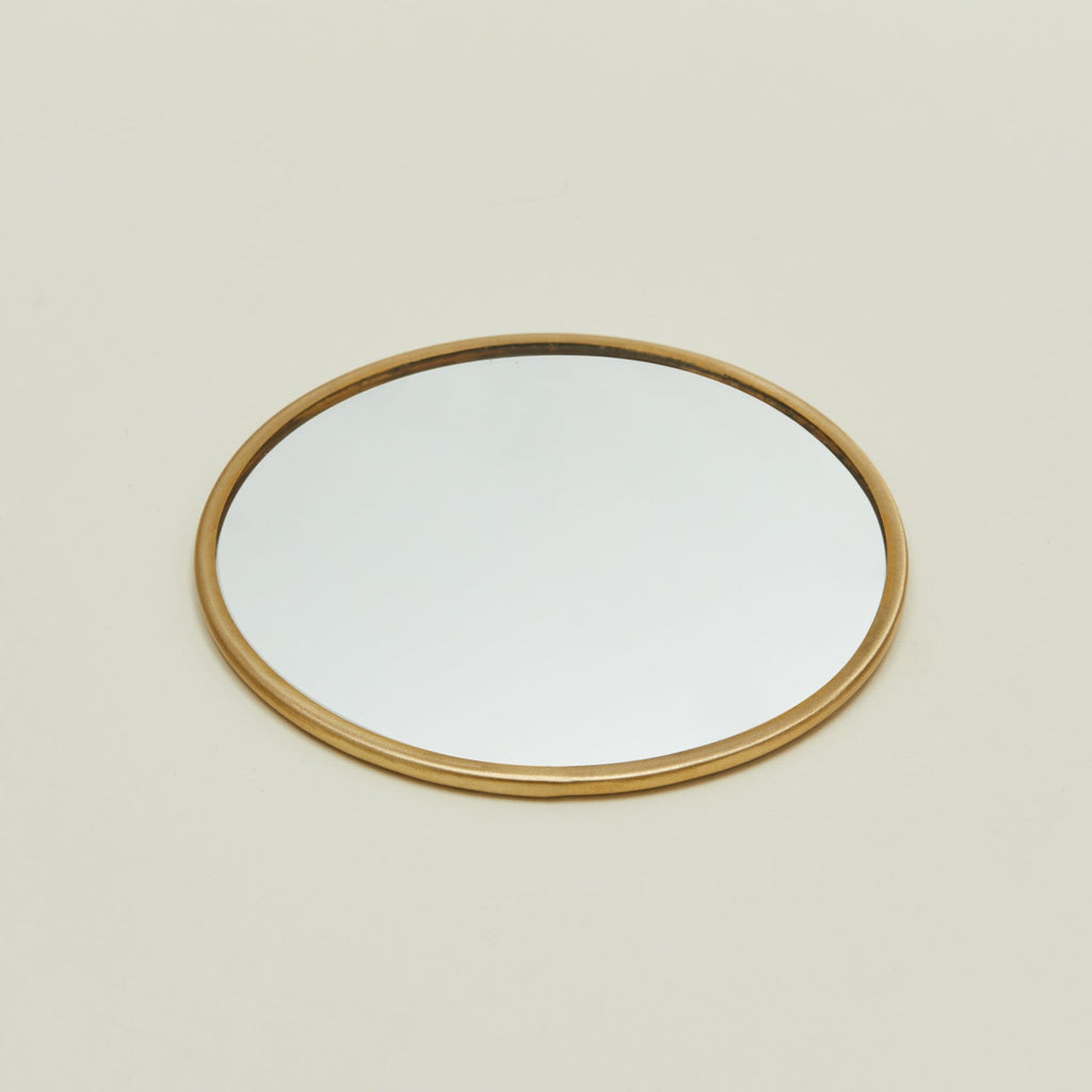 Detailed view of round brass mirror